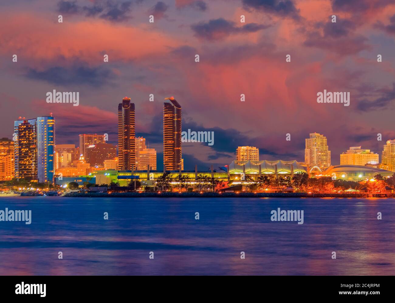 San Diego Bay is filled with color from the sunset and night lights of the San Diego skyline. Stock Photo