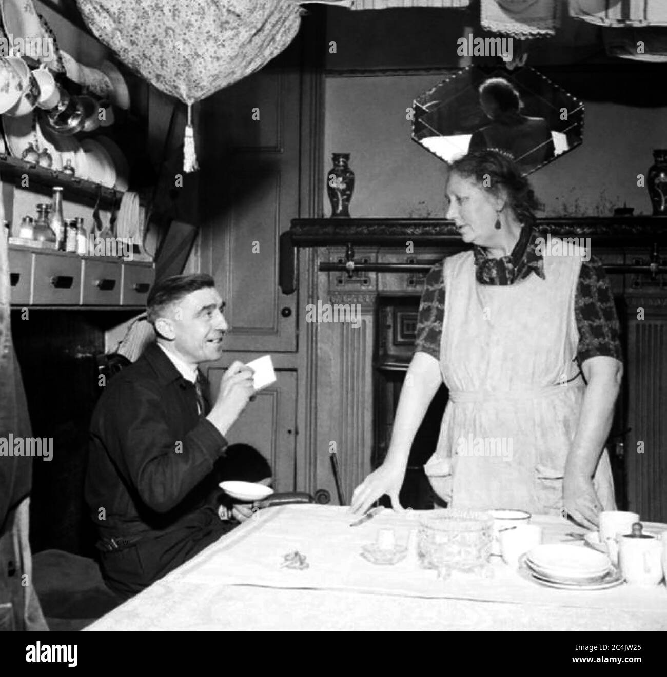 A typical 1940's/1950's seaside 'guest house' landlady in her kitchen. Stock Photo