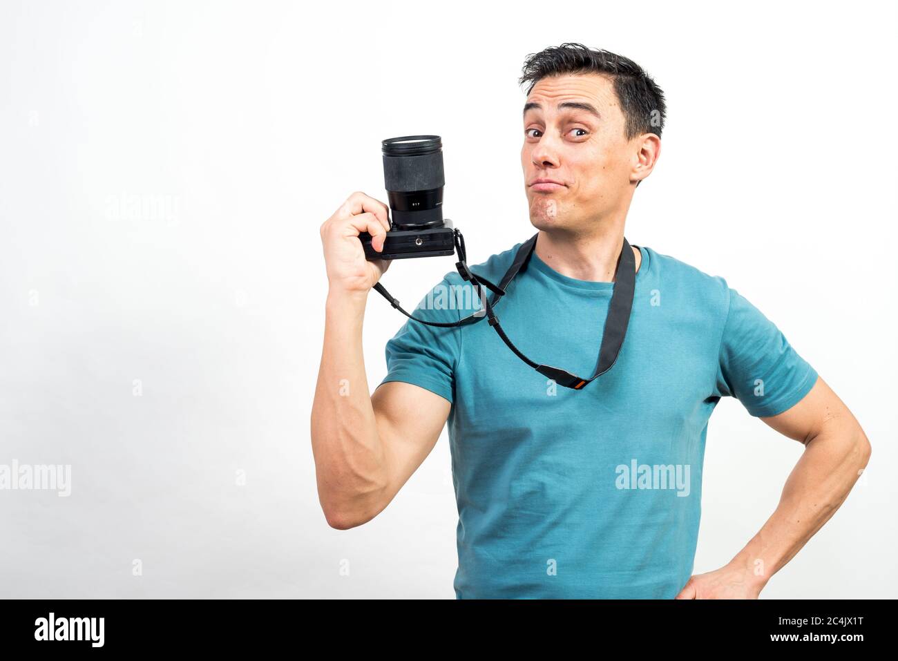Smiling man showing a photo camera. Mid shot. White background. Stock Photo