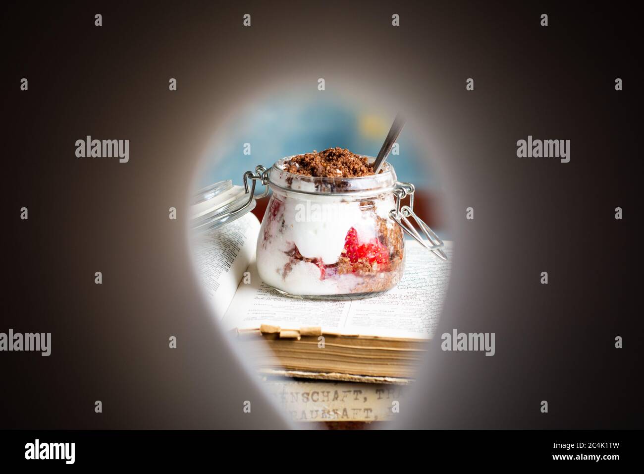 Strawberry parfait dessert in a glass jar on top of books closeup Stock Photo