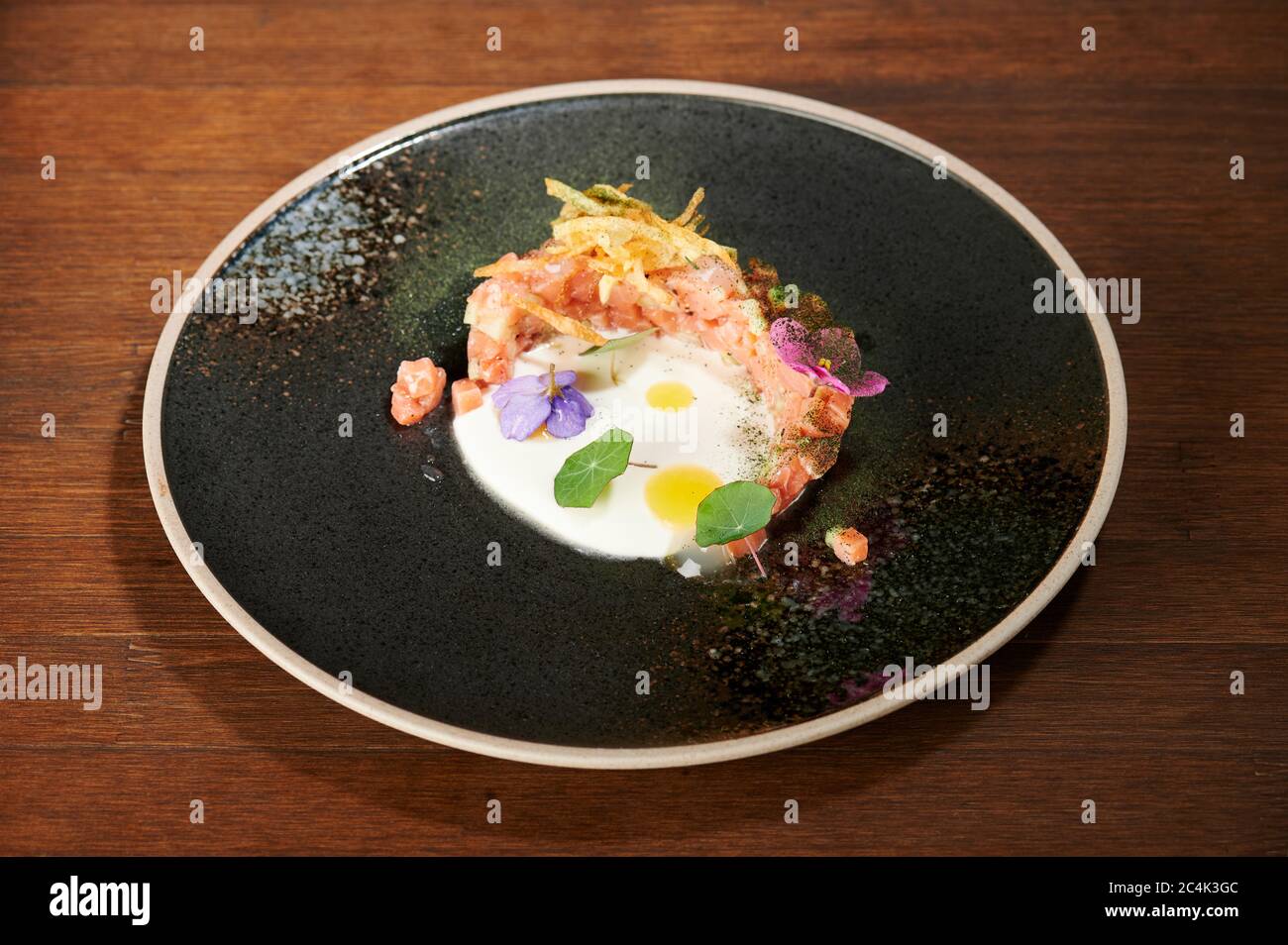 Healthy appetizer salmon tartare with flower pieces perspective view Stock Photo