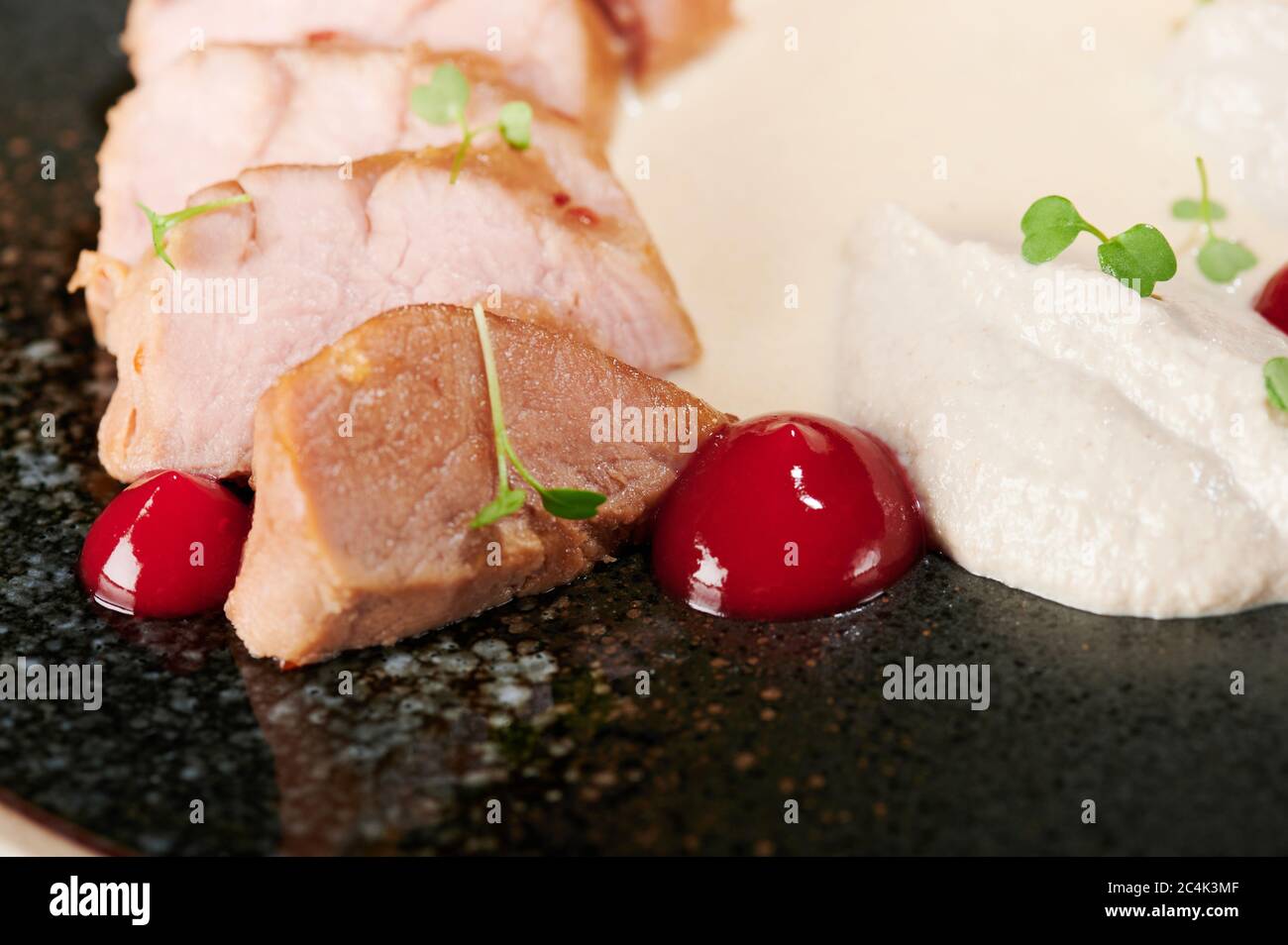 Juicy cooked pork meat with white sauce and herbs Stock Photo Alamy