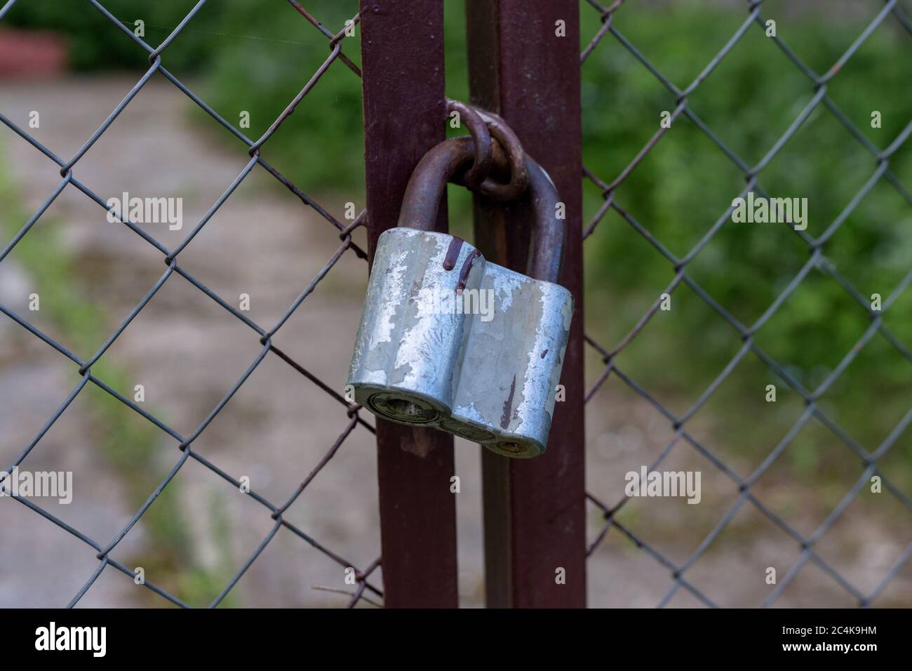 Gray lock on the gate. Property protection Stock Photo - Alamy