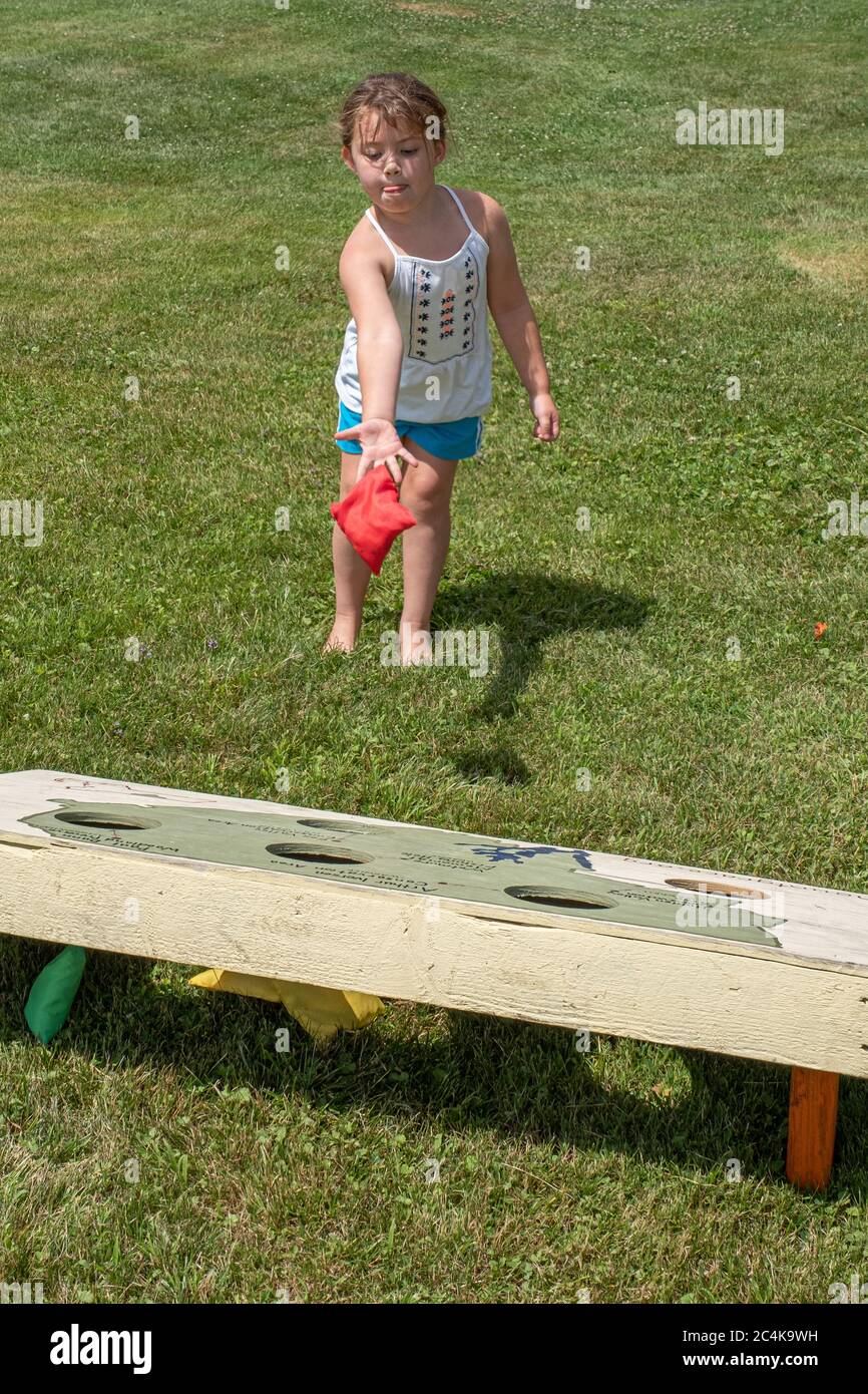 Little girl playing a game outside on a hot summer day Stock Photo