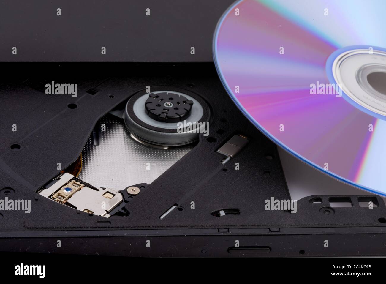 closeup of an open computer DVD CD drive with a rewritable DVD disk