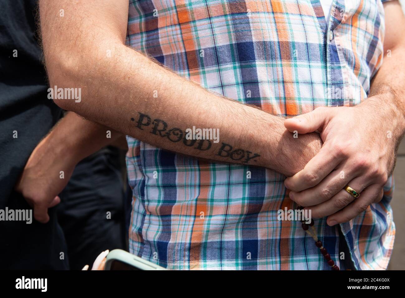 Saint Louis, Missouri, USA. 27th June, 2020. A man with a ''Proud Boys''  tattoo observes a protest calling for the statue of St. Louis to be removed  from Forest Park. Credit: James