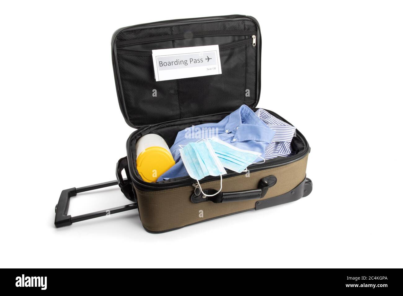 a carry on suitcase with a generic boarding pass, a surgical maskand disinfecting wipes suggesting the new normal for air travel after covid-19 corona Stock Photo