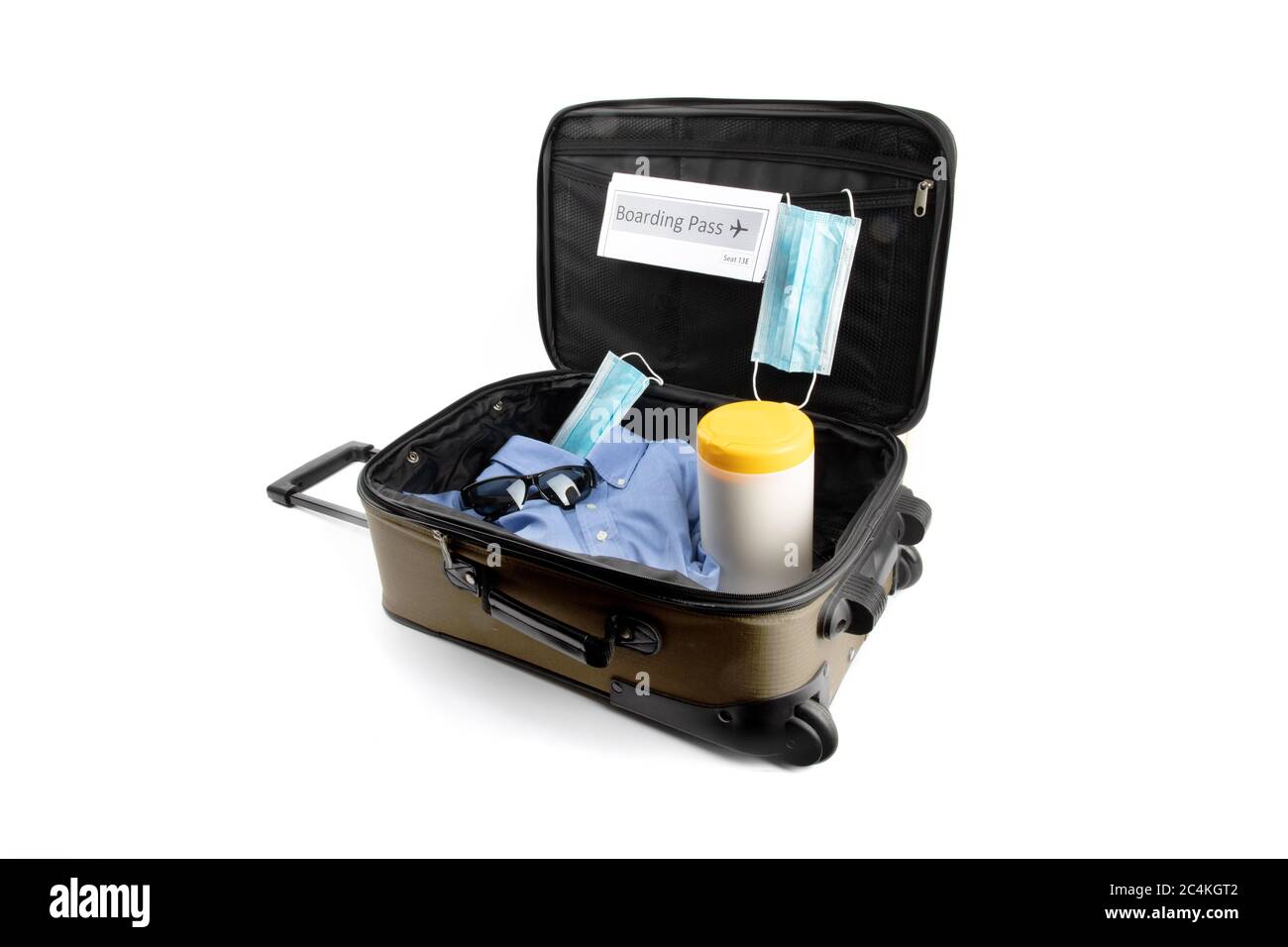 a carry on suitcase with a generic boarding pass, a surgical maskand