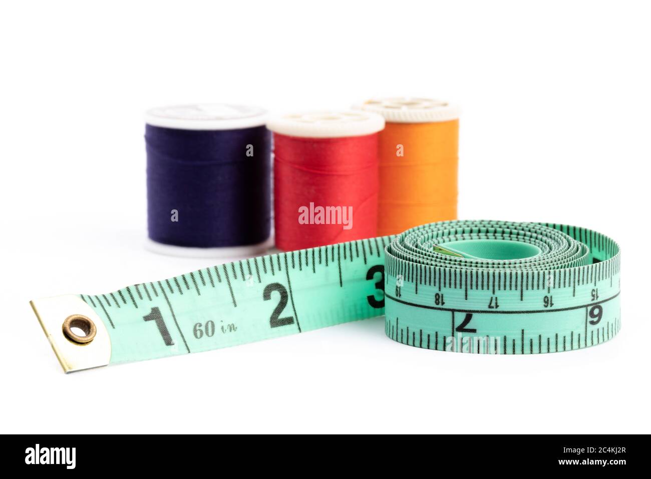 https://c8.alamy.com/comp/2C4KJ2R/a-green-tailors-cloth-tape-measure-with-spools-of-sewing-thread-in-the-background-isolated-on-white-2C4KJ2R.jpg