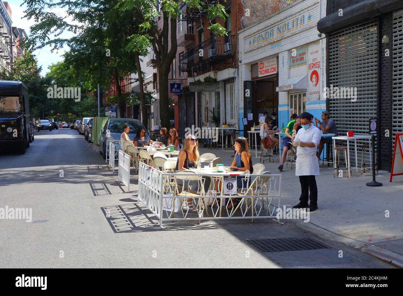 New York, NY. June 26, 2020. Socially distanced outdoor dining outside Tacombi in NoLiTa under Phase 2 reopening of New York City. Some restaurants and bars have expanded capacity by converting parking lanes into parklets, sidewalk extensions onto the roadway for dining and leisure, and not for car storage. Stock Photo