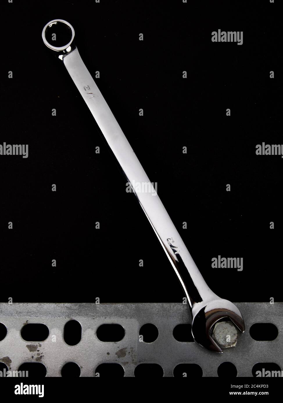 the open end of a combination box and open end wrench on a bolt head on