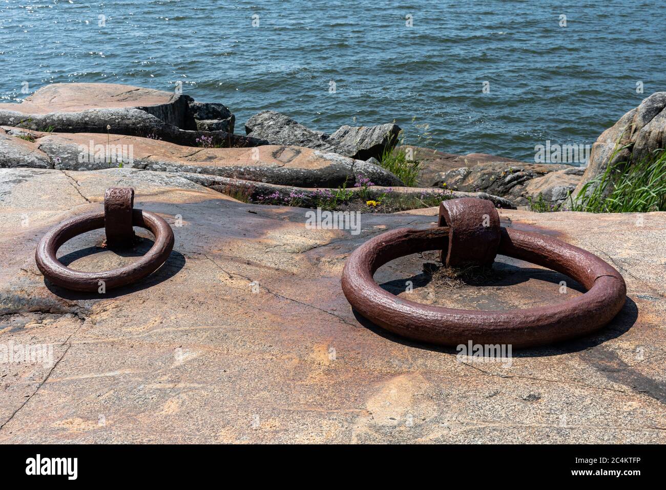 Rusty old mooring rings on a cliff in Vallisaari, former military island in Helsinki archipelago, Finland Stock Photo