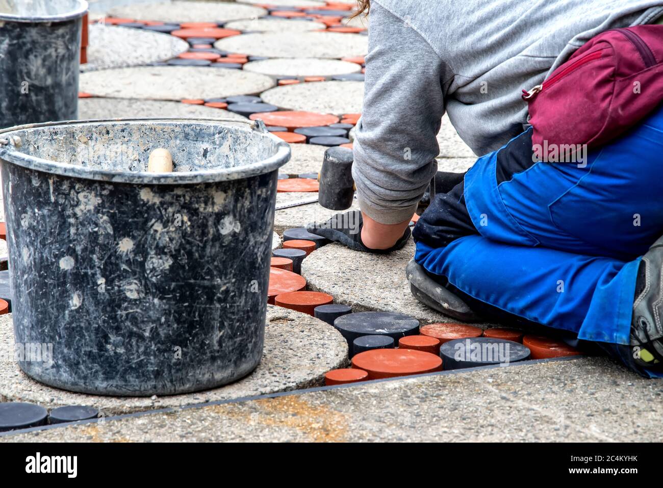 Round exposed aggregate concrete slabs decorated with red and grey terracotta stones. Beautiful pattern for the outside area or garden Stock Photo