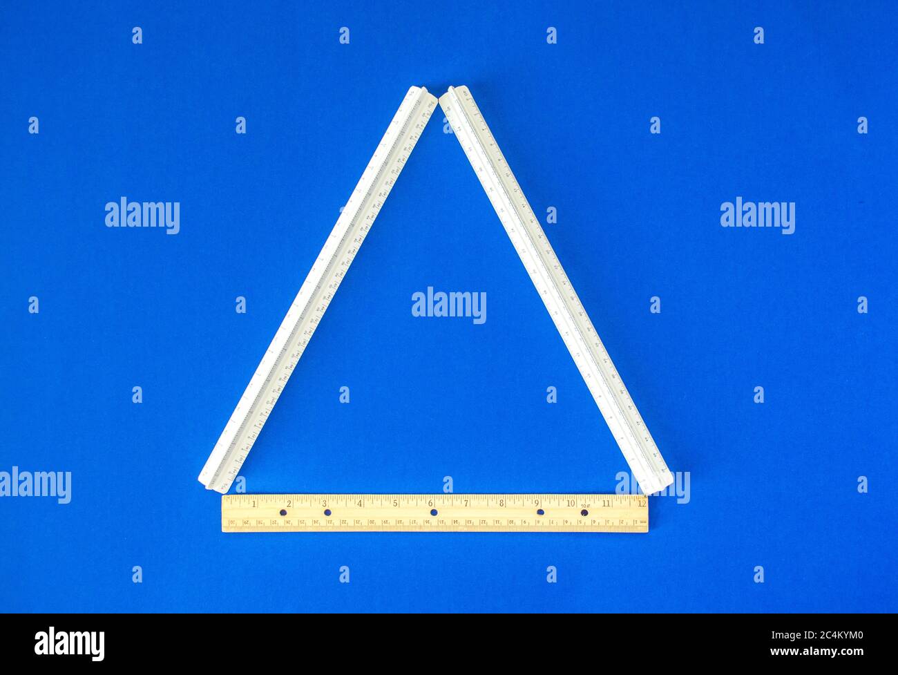 a triangle formed by three rulers on a bright blue background Stock Photo