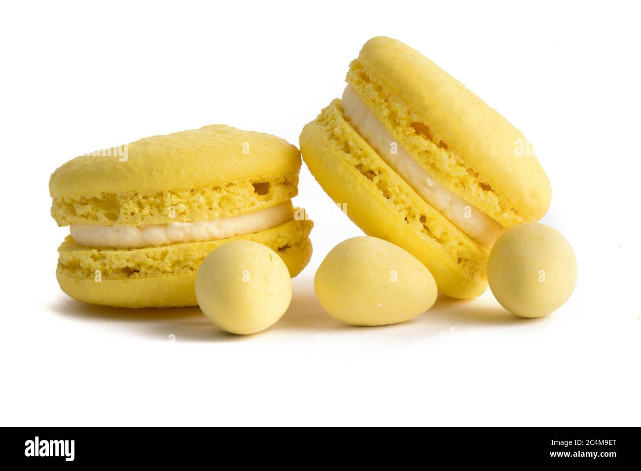 extreme macro closeup of yellow macaroon cookies and yellow mini Easter eggs on a white background Stock Photo