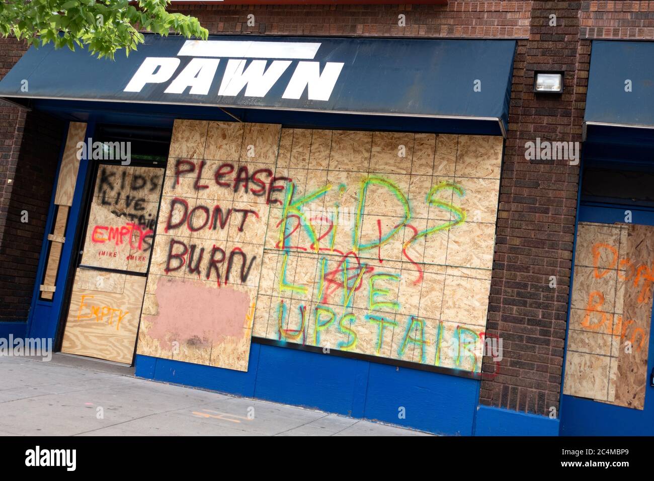 Pawn shop boarded up on Lake Street with 'kids Live upstairs' 'Please don't Burn' after George Floyd death and riots. Minneapolis Minnesota MN USA Stock Photo