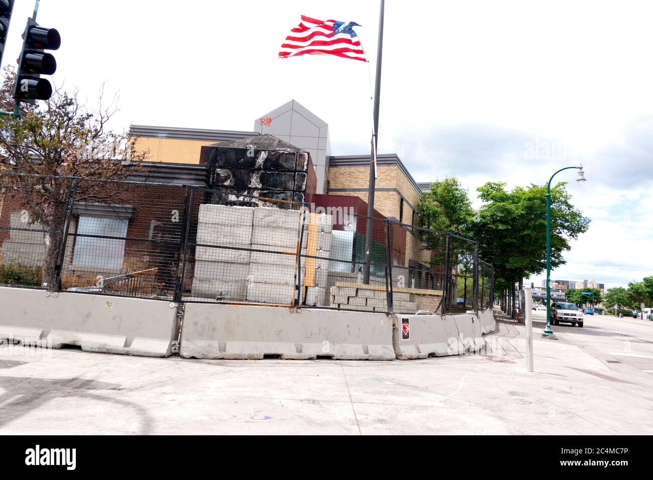 Entrance of 3rd Precinct Police building burned down with the American flag flying overhead after George Floyd death Minneapolis Minnesota MN USA Stock Photo