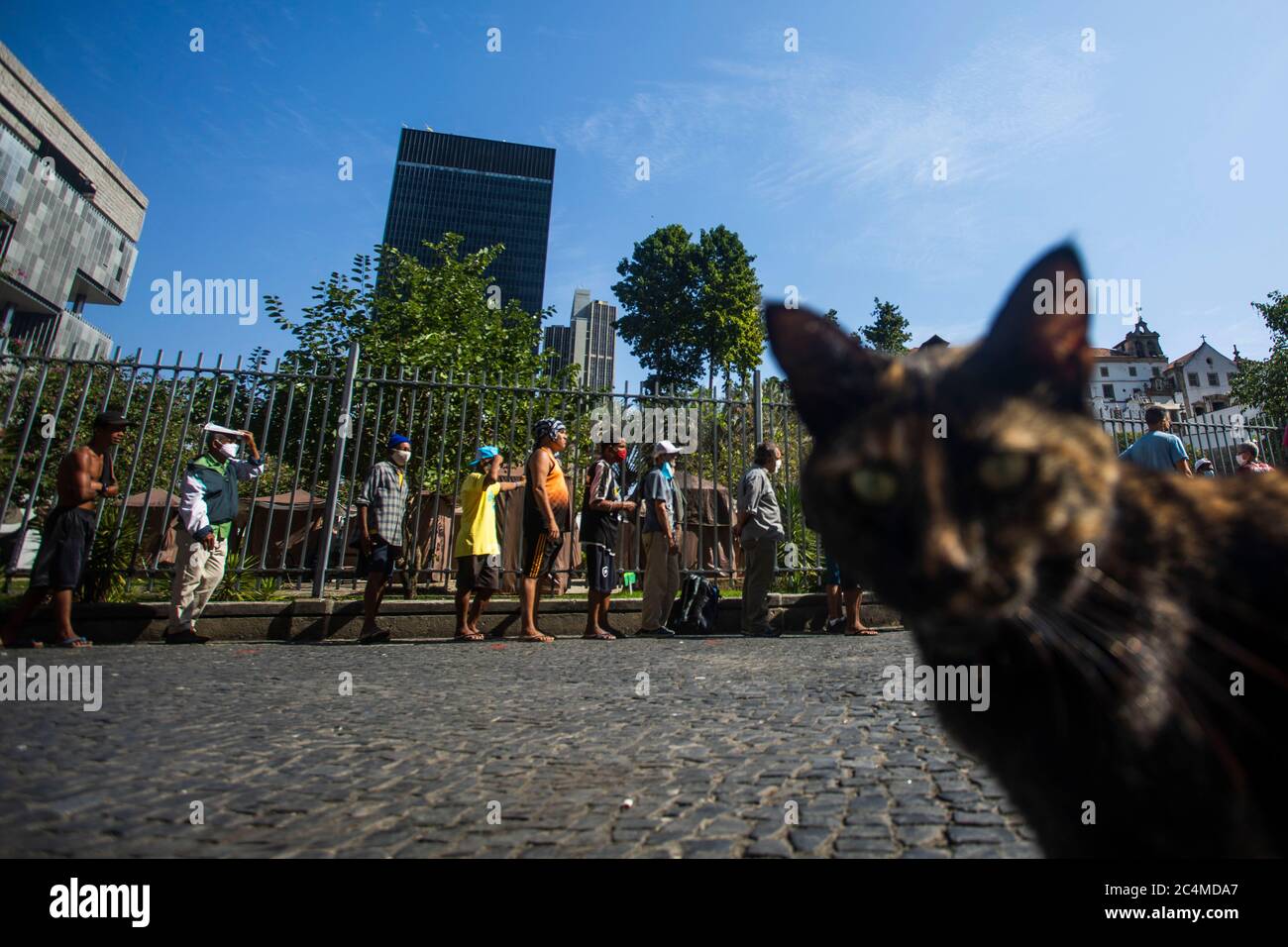 June 26, 2020, Rio De Janeiro, Rio de Janeiro, Brazil: A queue of people in a vulnerable situation forms to receive food in a Franciscan Action that donate meals to the homeless and unemployed in Largo da Carioca, in downtown Rio de Janeiro, amid the increasing impacts of the new pandemic coronavirus. The action, carried out by volunteers and the friars of the Franciscan Solidarity Service (Sefras), in partnership with the Santo AntÃ´nio Convent and the SÃ£o BonifÃ¡cio Parish, from Germany, has already donated more than 10,000 meals in 20 days, delivering an average 450 daily meals, between lu Stock Photo
