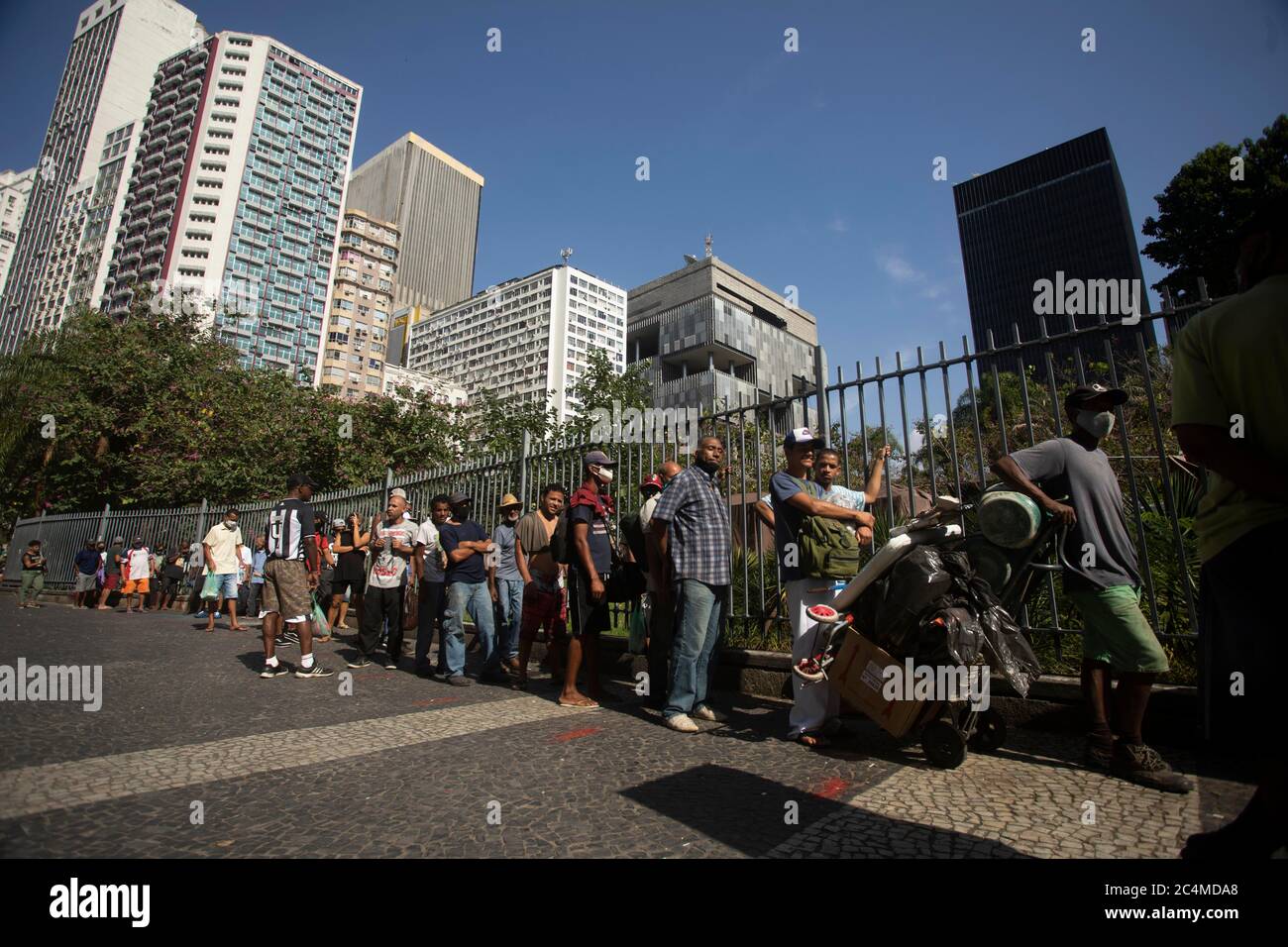 June 26, 2020, Rio De Janeiro, Rio de Janeiro, Brazil: A queue of people in a vulnerable situation forms to receive food in a Franciscan Action that donate meals to the homeless and unemployed in Largo da Carioca, in downtown Rio de Janeiro, amid the increasing impacts of the new pandemic coronavirus. The action, carried out by volunteers and the friars of the Franciscan Solidarity Service (Sefras), in partnership with the Santo AntÃ´nio Convent and the SÃ£o BonifÃ¡cio Parish, from Germany, has already donated more than 10,000 meals in 20 days, delivering an average 450 daily meals, between lu Stock Photo