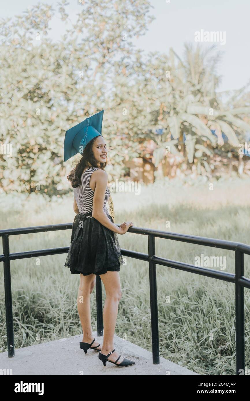 Portrait of a Filipino Woman wearing her Graduation cap, gown and Sash