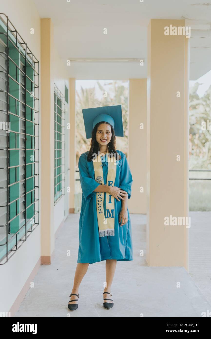 Portrait of a Filipino Woman wearing her Graduation cap, gown and Sash