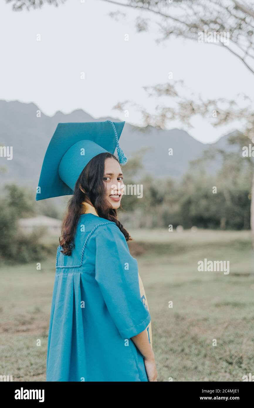 Portrait of a Filipino Woman wearing her Graduation cap, gown and Sash