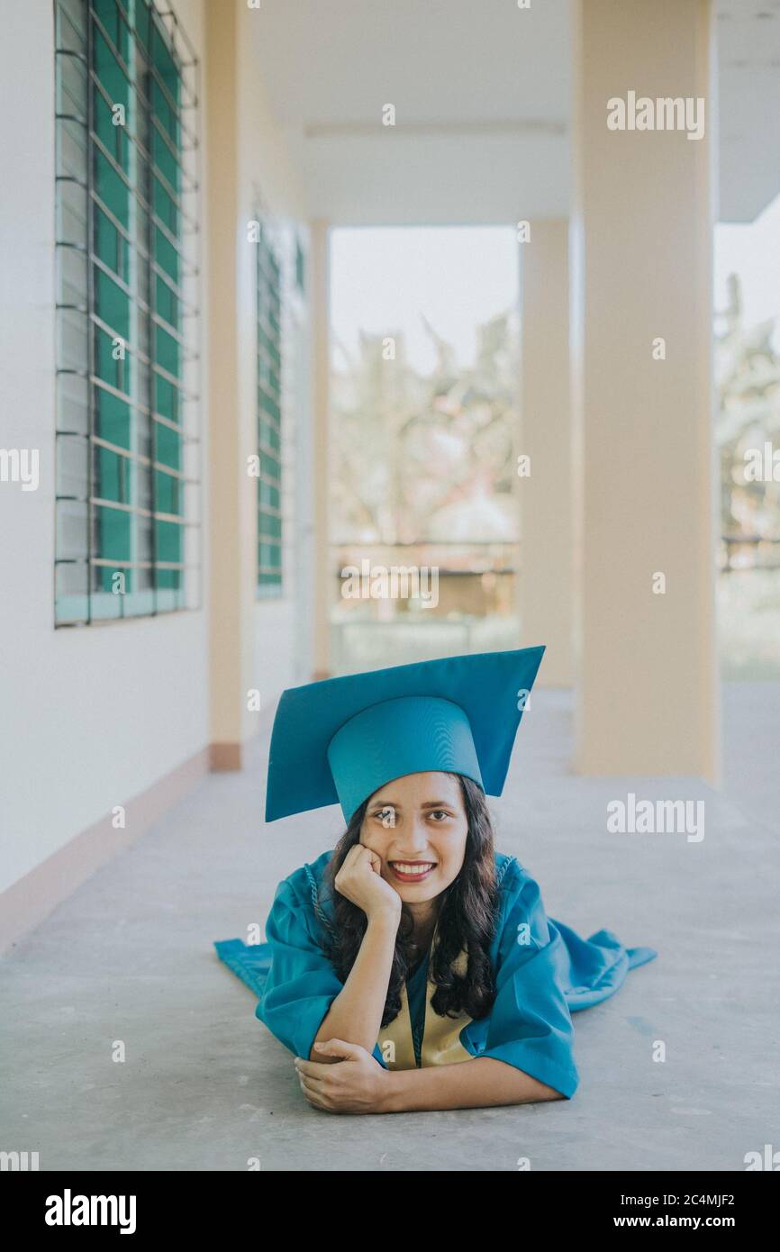 Portrait of a Filipino Woman wearing her Graduation cap, gown and Sash