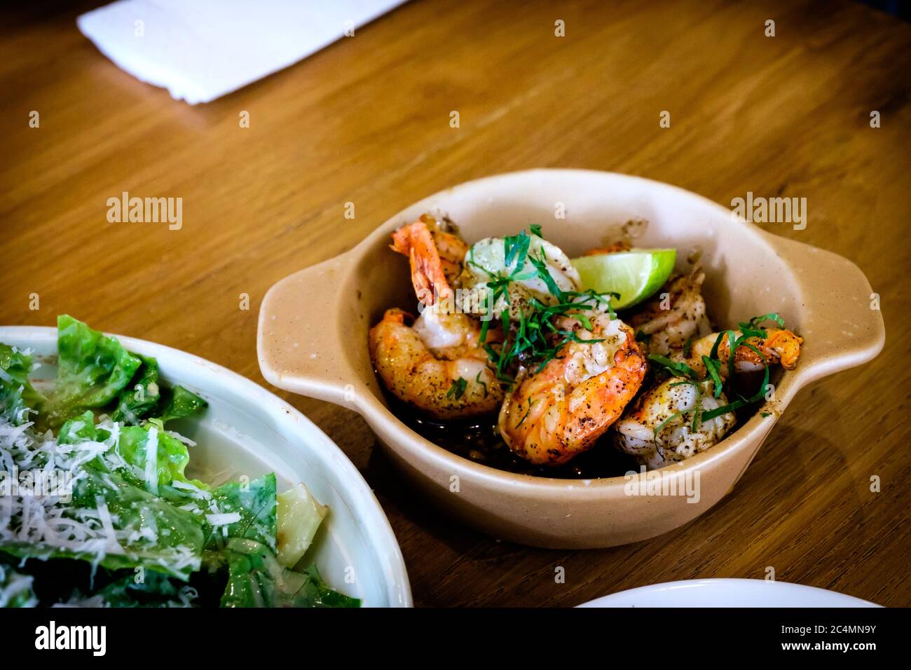 Freshly delicious grilled Gambas al Ajillo, Spanish style sizzling chilli-and-garlic Tapas shrimp pinchos, served on a wooden table Stock Photo