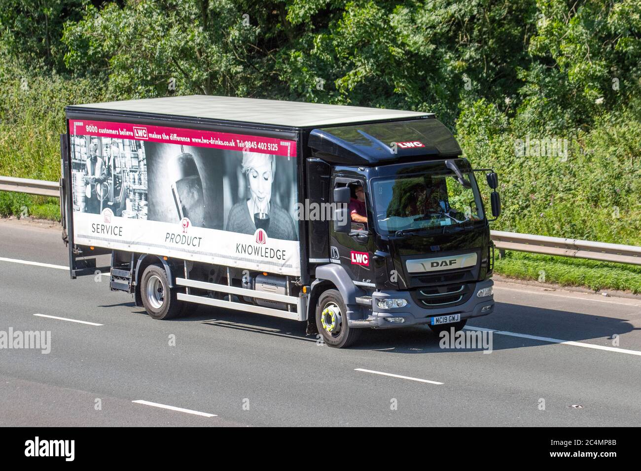 LWC Transport Limited independent drinks wholesaler, delivering beer, wine spirits and soft drinks; Rigid Haulage delivery trucks, box van lorry, transportation, truck, cargo carrier, 2019 black DAF LF  vehicle, European commercial transport industry HGV, M6 at Manchester, UK Stock Photo
