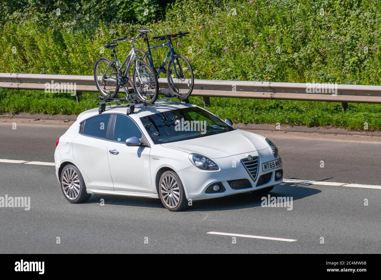 2015 white Alfa Romeo Giulietta Exclusive Jtdm-; Vehicular traffic moving vehicles, cars driving vehicle on UK roads, motors, motoring on the M6 motorway highway Stock Photo