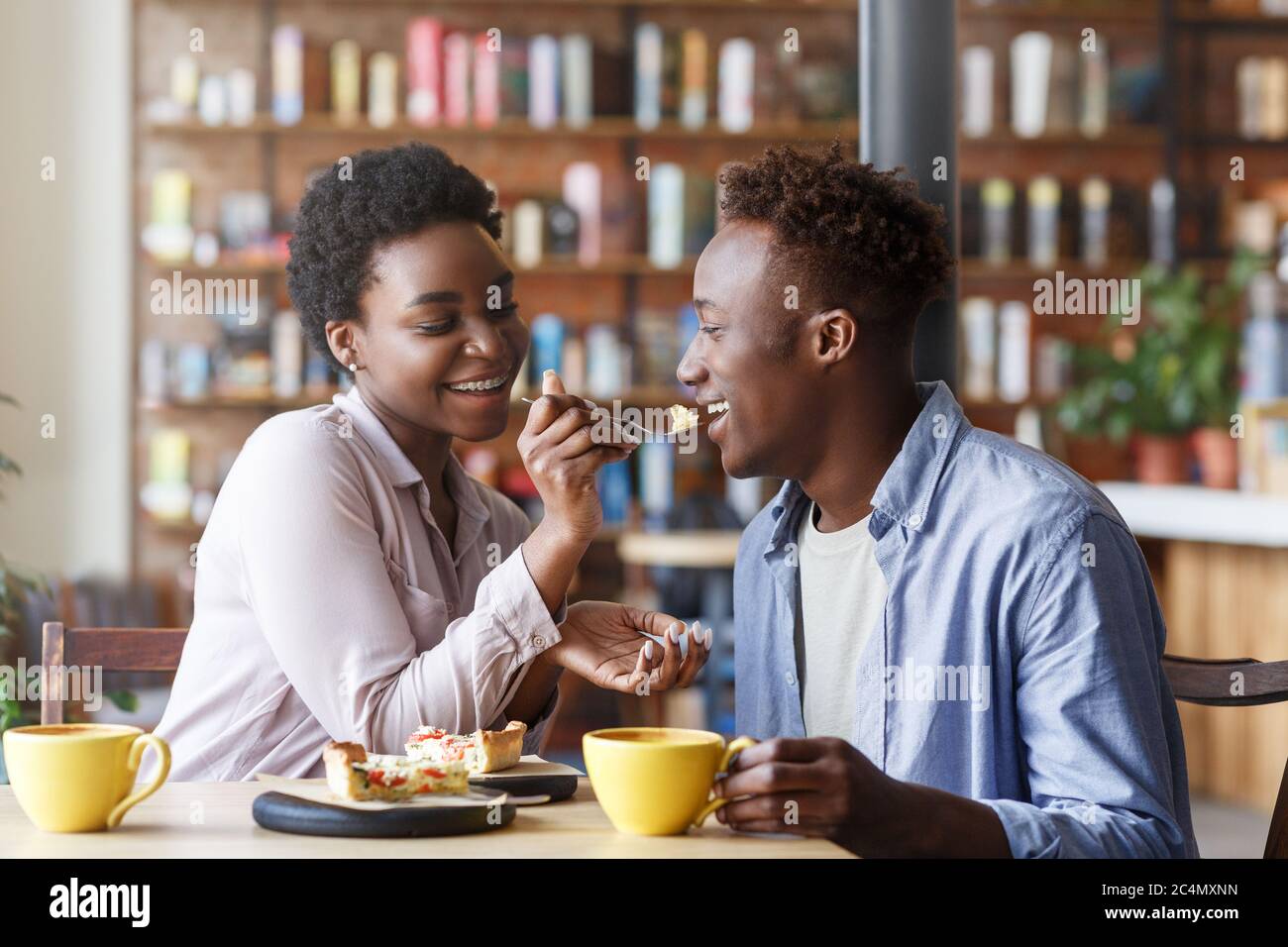 Beautiful Black Girl Feeding Yummy Pie To Her Boyfriend At Cozy Cafe Stock Photo - Alamy