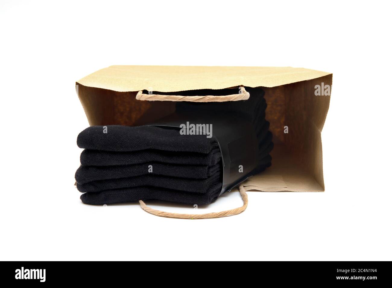 Pack of five black socks in a brown shopping bag isolated on white. Stock Photo