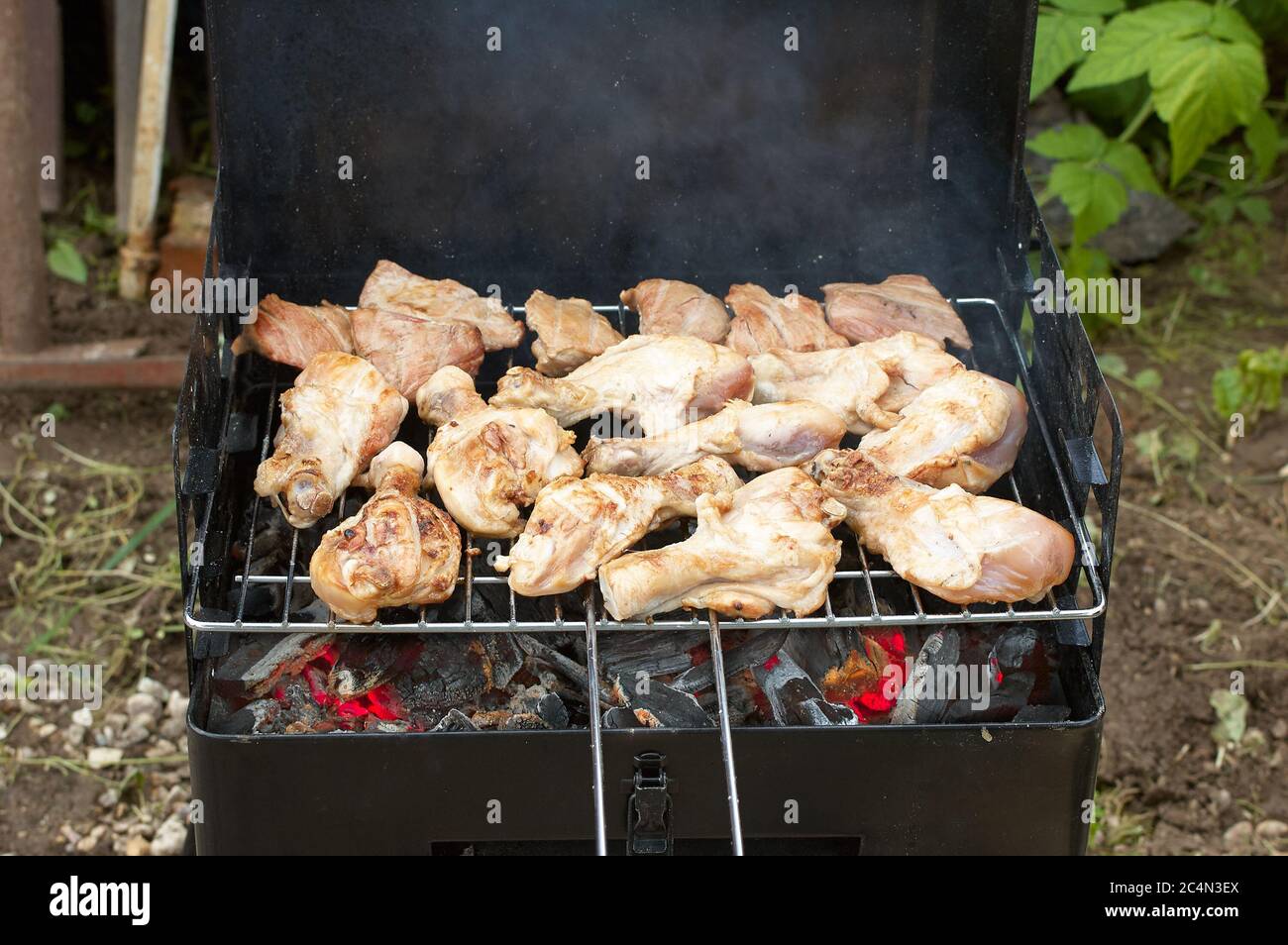 BBQ Chicken Legs Roasted On The Hot Flaming Charcoal Grill, Top View Close Up Stock Photo