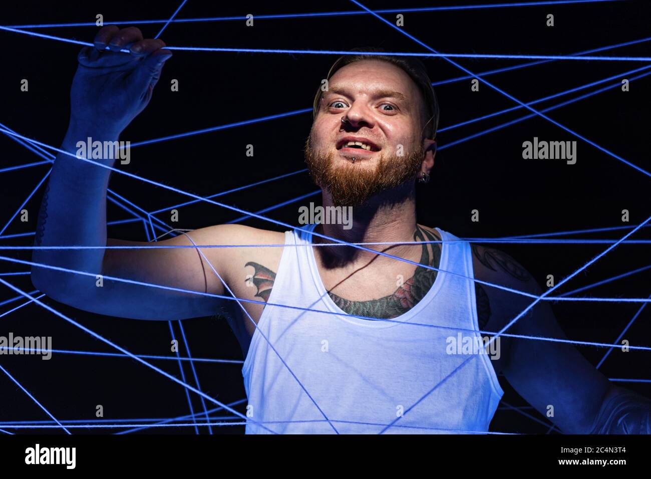 Crazy man tangled in threads in neon light Stock Photo