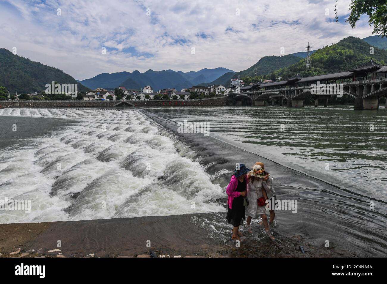 Hangzhou, China's Zhejiang Province. 28th June, 2020. Tourists visit a dam with scale-shaped geometric structures on the Huyuan River in Huyuan Township of Fuyang District, Hangzhou, east China's Zhejiang Province, June 28, 2020. Township-level governments in Fuyang District have worked in collaboration to maximize the Huyuan River's ecological resources and promote local ecotourism. Credit: Xu Yu/Xinhua/Alamy Live News Stock Photo
