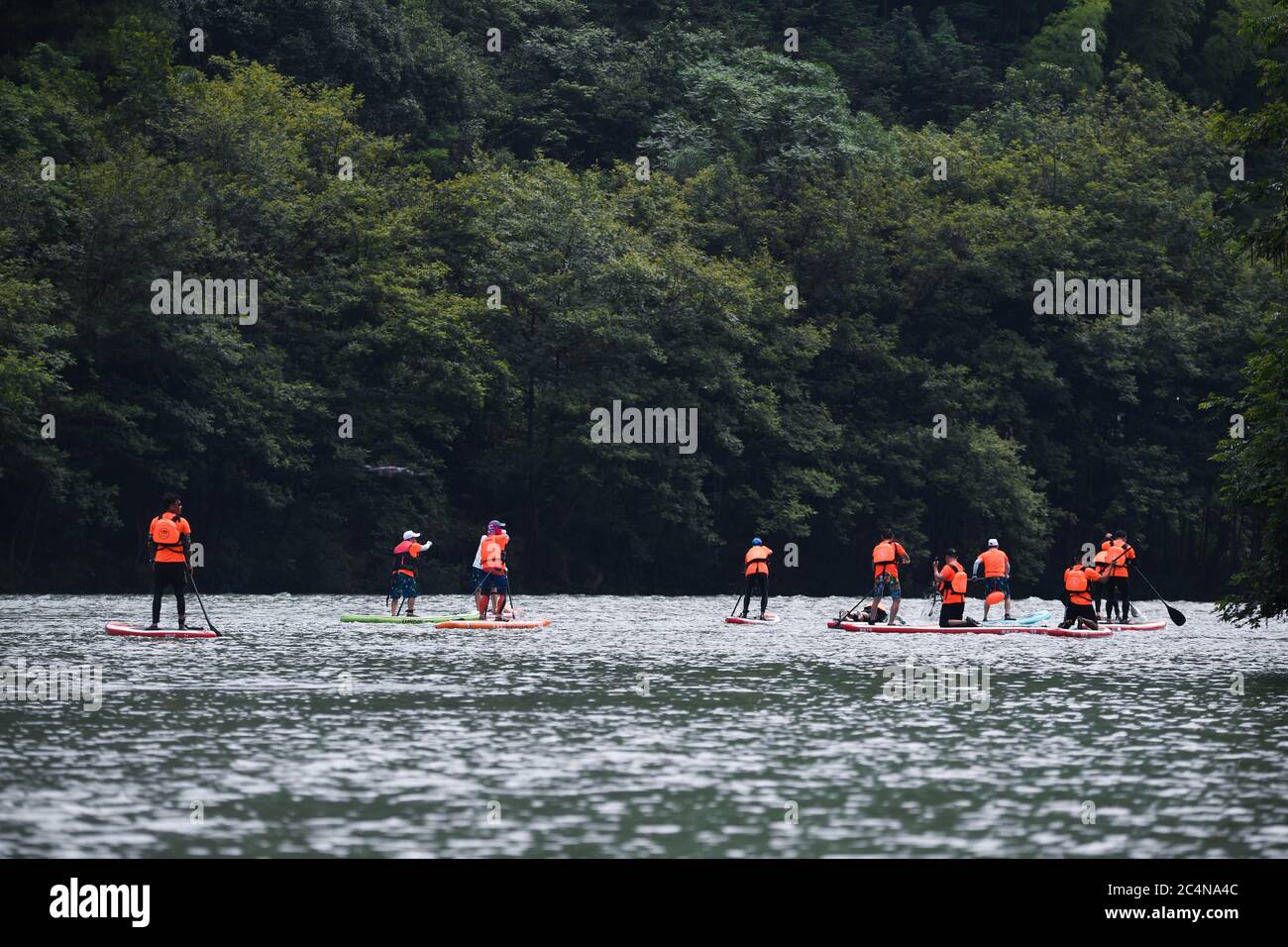 Hangzhou, China's Zhejiang Province. 28th June, 2020. Water sports enthusiasts participate in a paddleboarding activity on the Huyuan River in Huyuan Township of Fuyang District, Hangzhou, east China's Zhejiang Province, June 28, 2020. Township-level governments in Fuyang District have worked in collaboration to maximize the Huyuan River's ecological resources and promote local ecotourism. Credit: Xu Yu/Xinhua/Alamy Live News Stock Photo