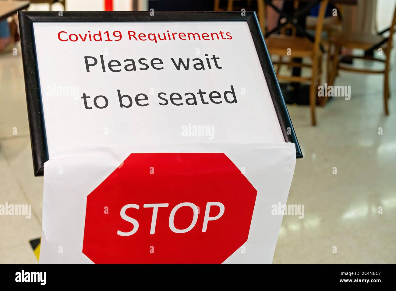 Townsville, Queensland, Australia - June 2020: Please wait to be seated sign at coffee shop during Covid-19 restrictions Stock Photo