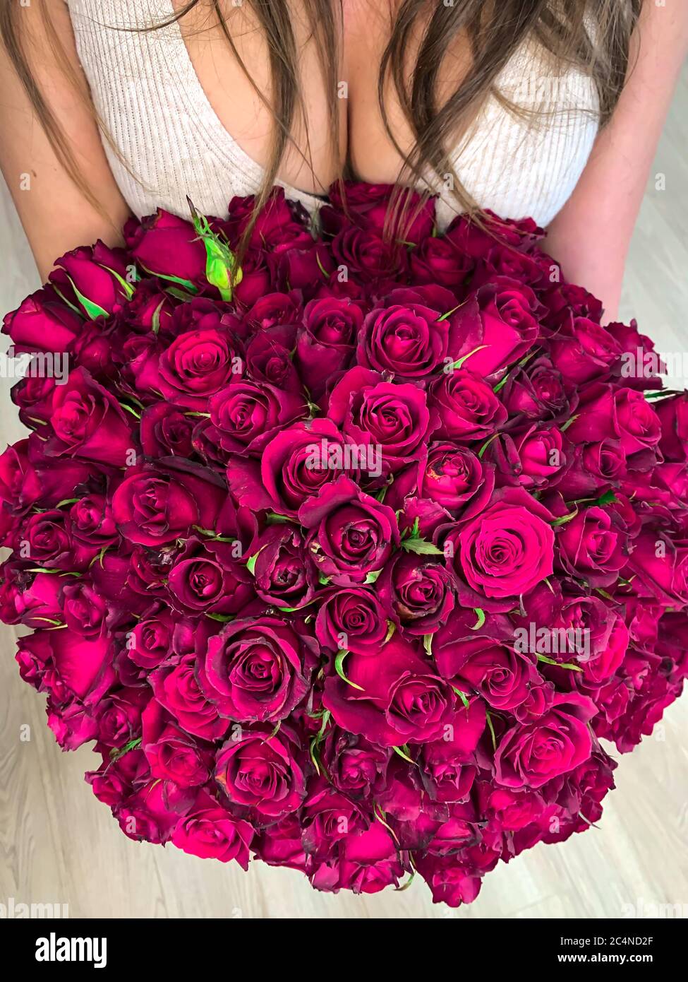 A young girl holding in hands a huge bouquet of 101 wonderful purple ...
