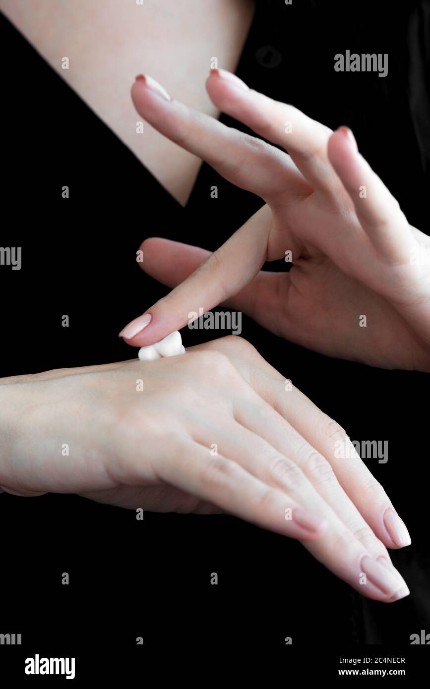 Closeup of a drop of cream on female hands. Moisturizing hands. Skin