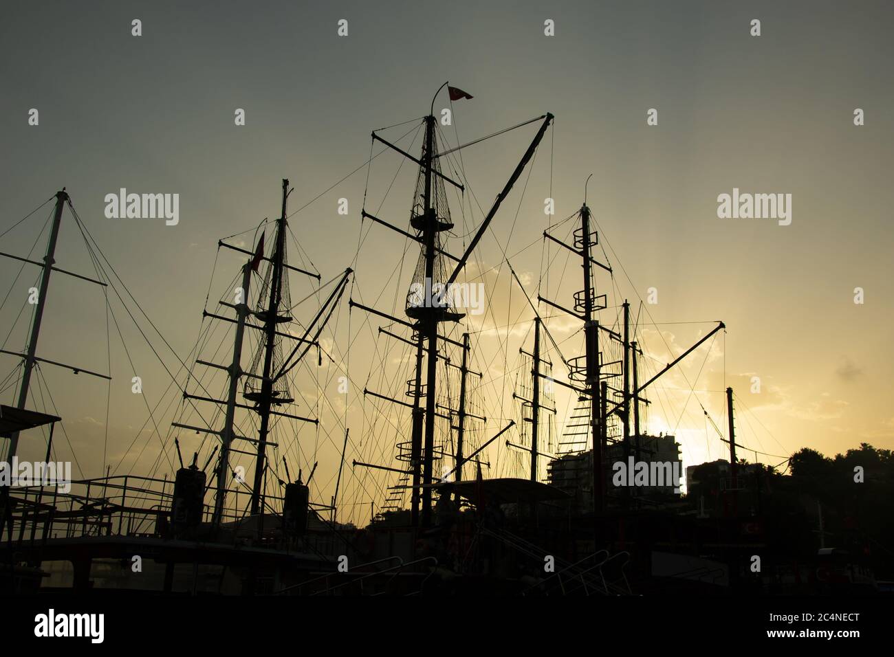 Silhouettes of ship masts on the sunset sky background. Stock image ...