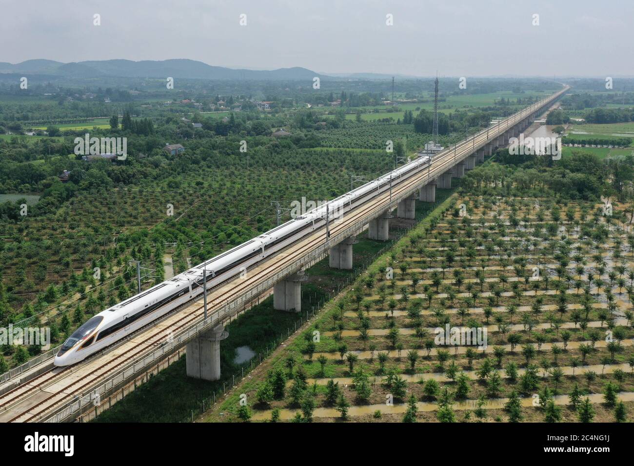 Hangzhou. 28th June, 2020. Aerial photo taken on June 28, 2020 shows a bullet train running on the Shangqiu-Hefei-Hangzhou high-speed railway in Anji County, east China's Zhejiang Province. A new high-speed railway route connecting east and central China started operation on Sunday. With a designed speed of 350 kph, the route connects the city of Shangqiu in central China's Henan Province, and Hefei and Hangzhou, the capital cities of east China's Anhui and Zhejiang provinces. Credit: Huang Zongzhi/Xinhua/Alamy Live News Stock Photo