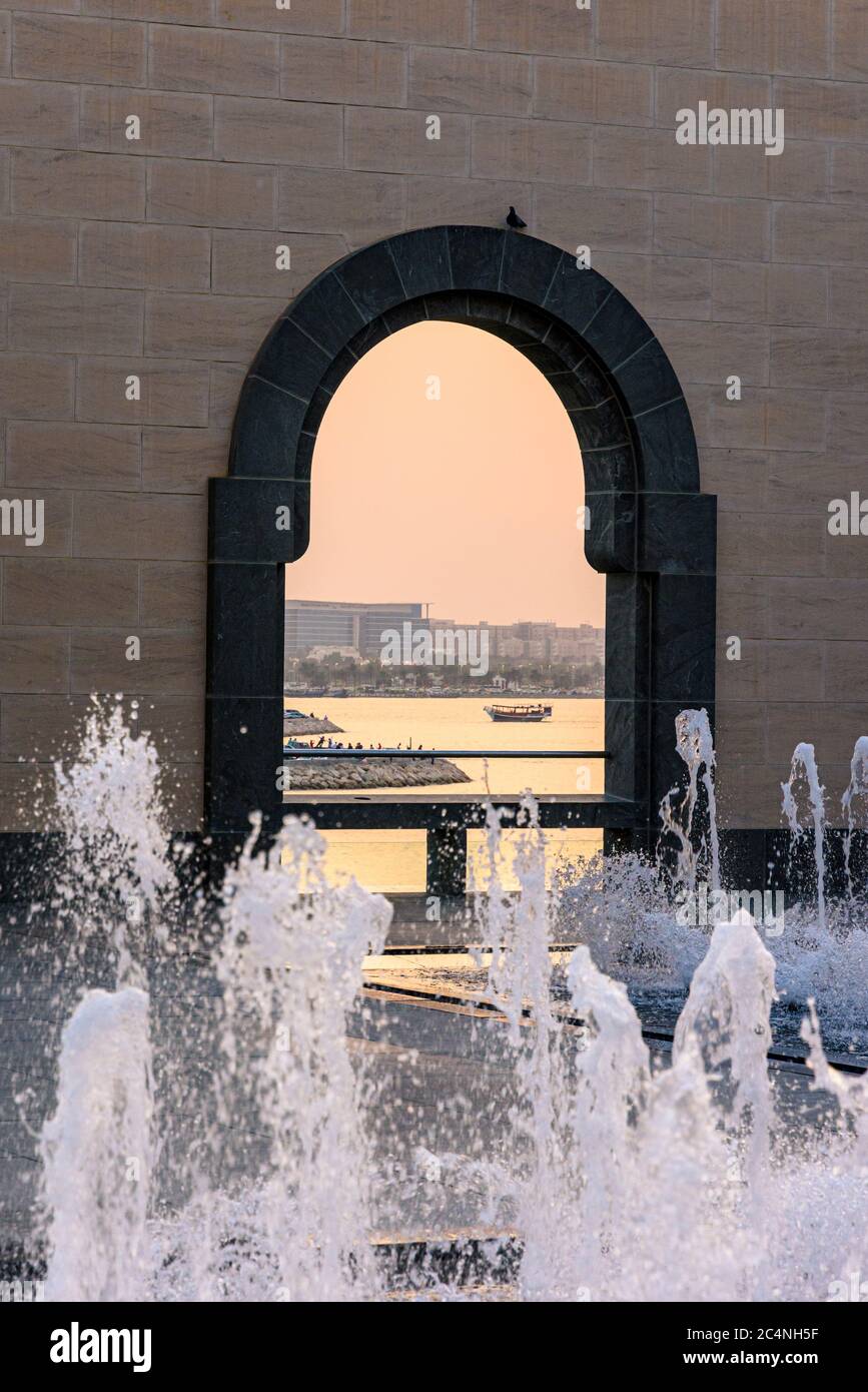 Framed dhow views at sunset through the arches of the courtyard at the Museum of Islamic Art, Doha, Qatar Stock Photo