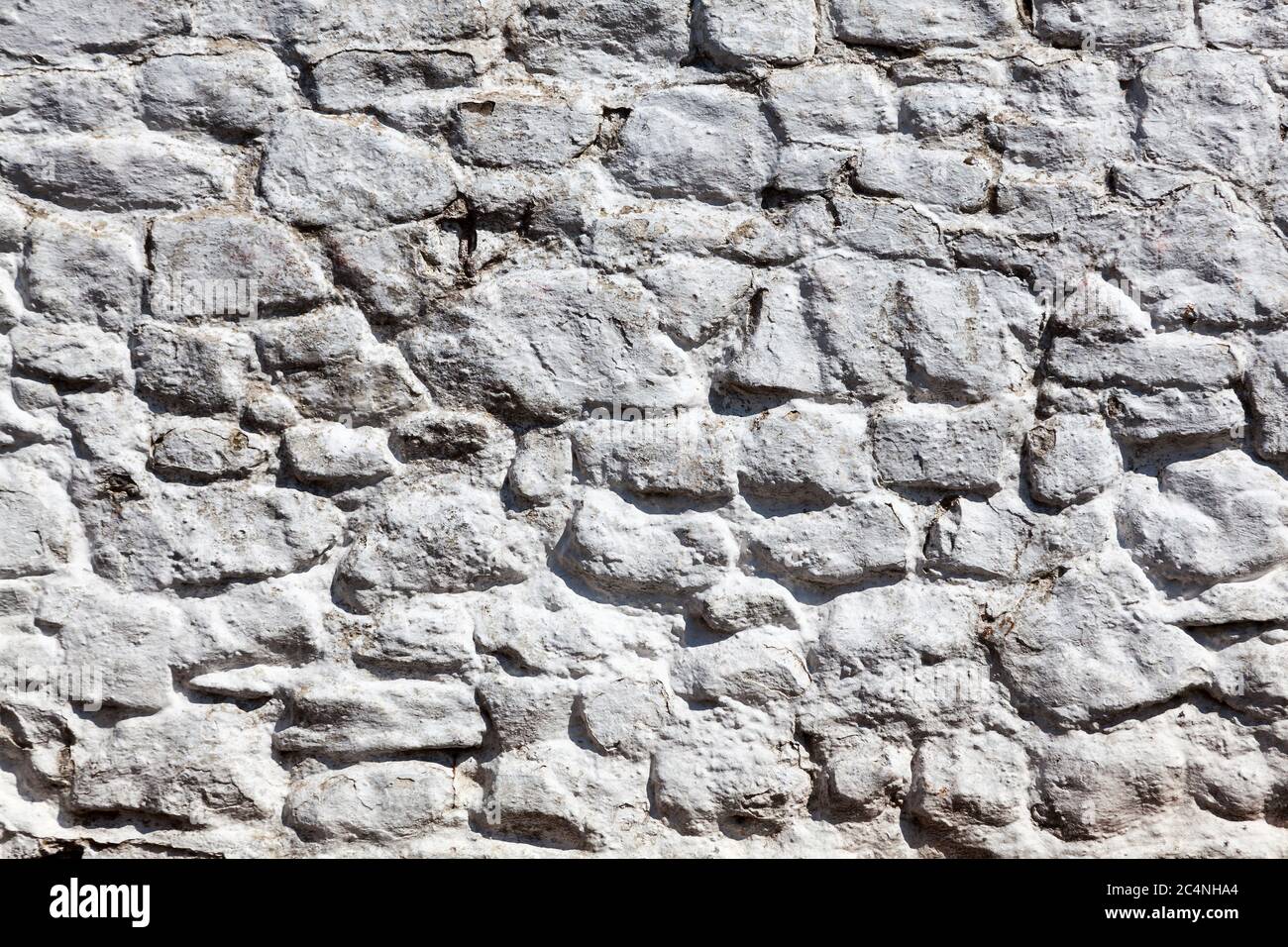 Old grey white weathered rough stone wall texture background Stock Photo