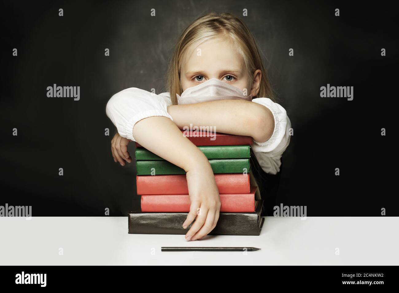 Tired child girl in protective medical mask on black background Stock Photo