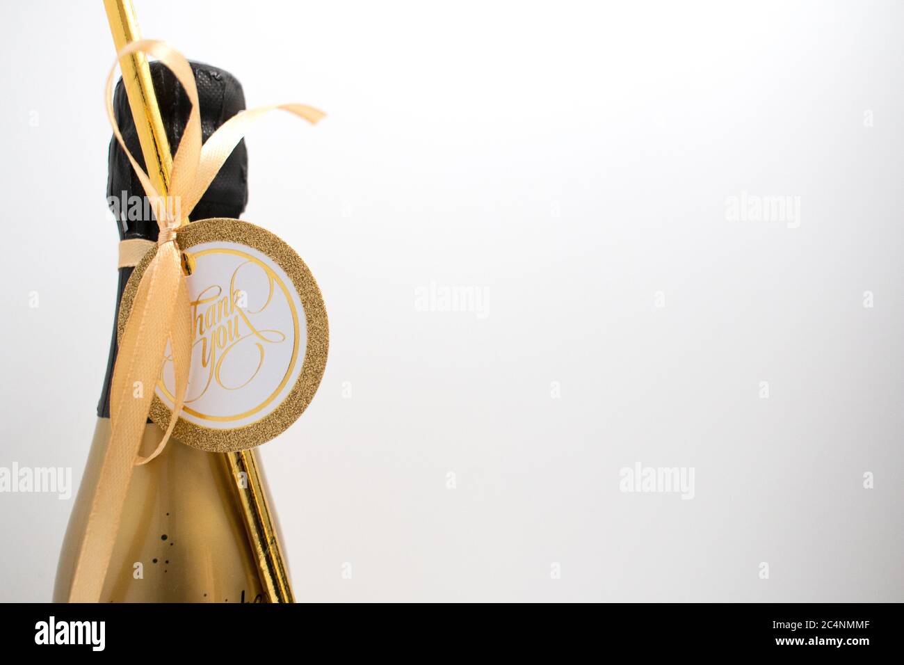 A champagne bottle with a card saying Thank You. A token of appreciation. Stock Photo