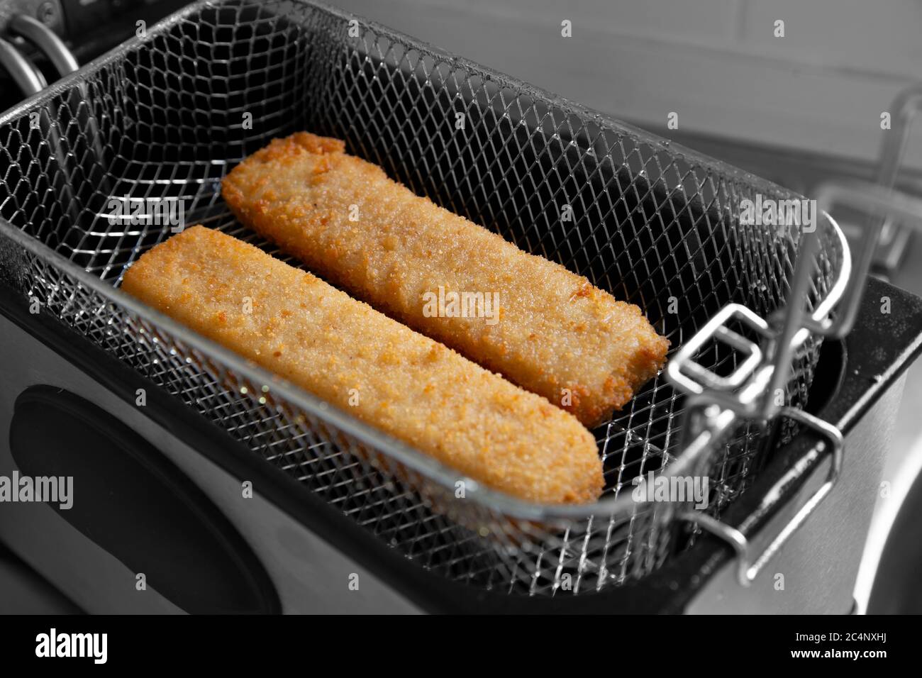 Fish fingers in a mesh basket, cooked in an electric deep fat fryer