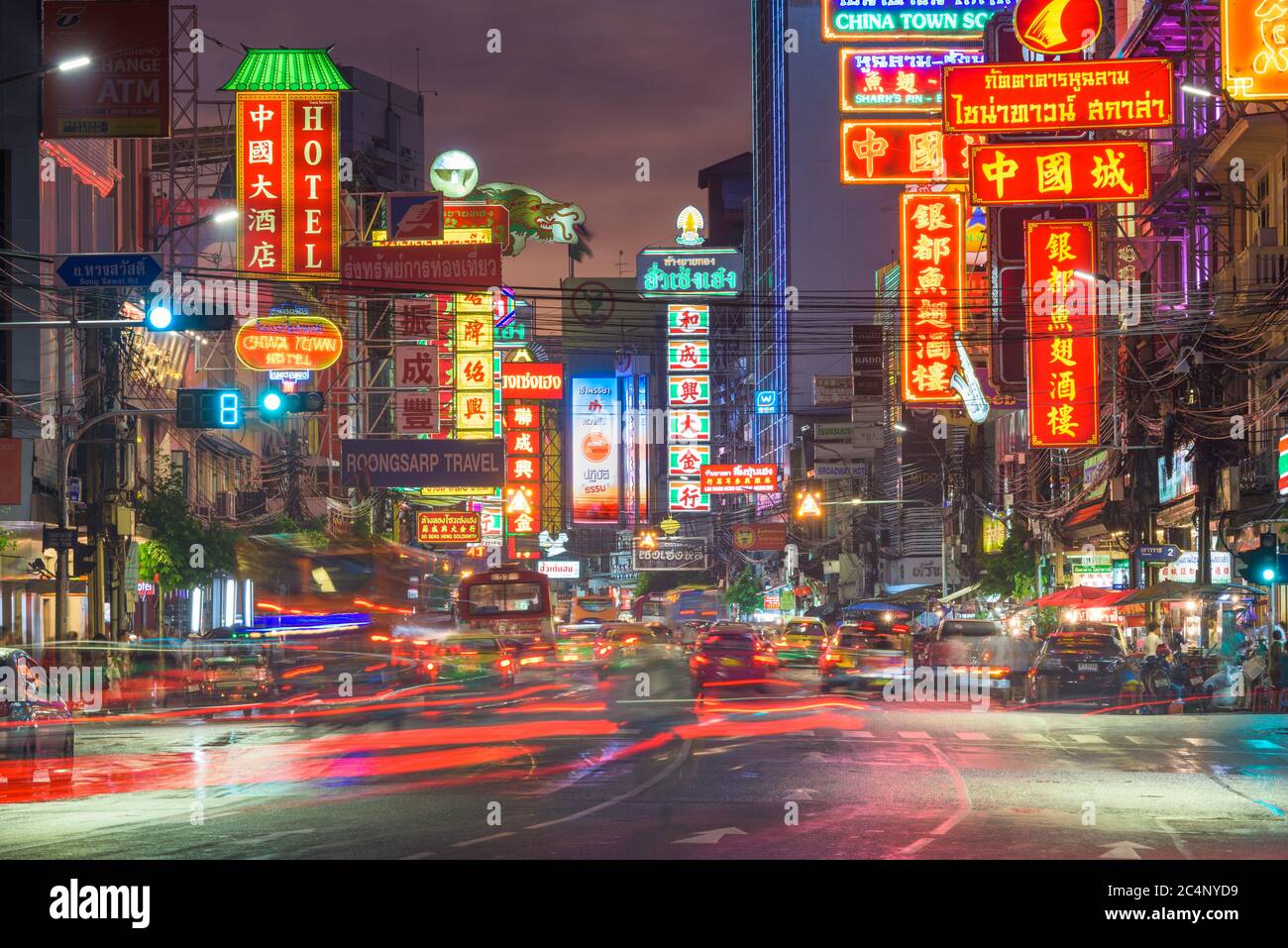 BANGKOK, THAILAND - SEPTEMBER 27, 2015: Traffic on Yaowarat Road passes below lit signs in the Chinatown district at dusk. Stock Photo