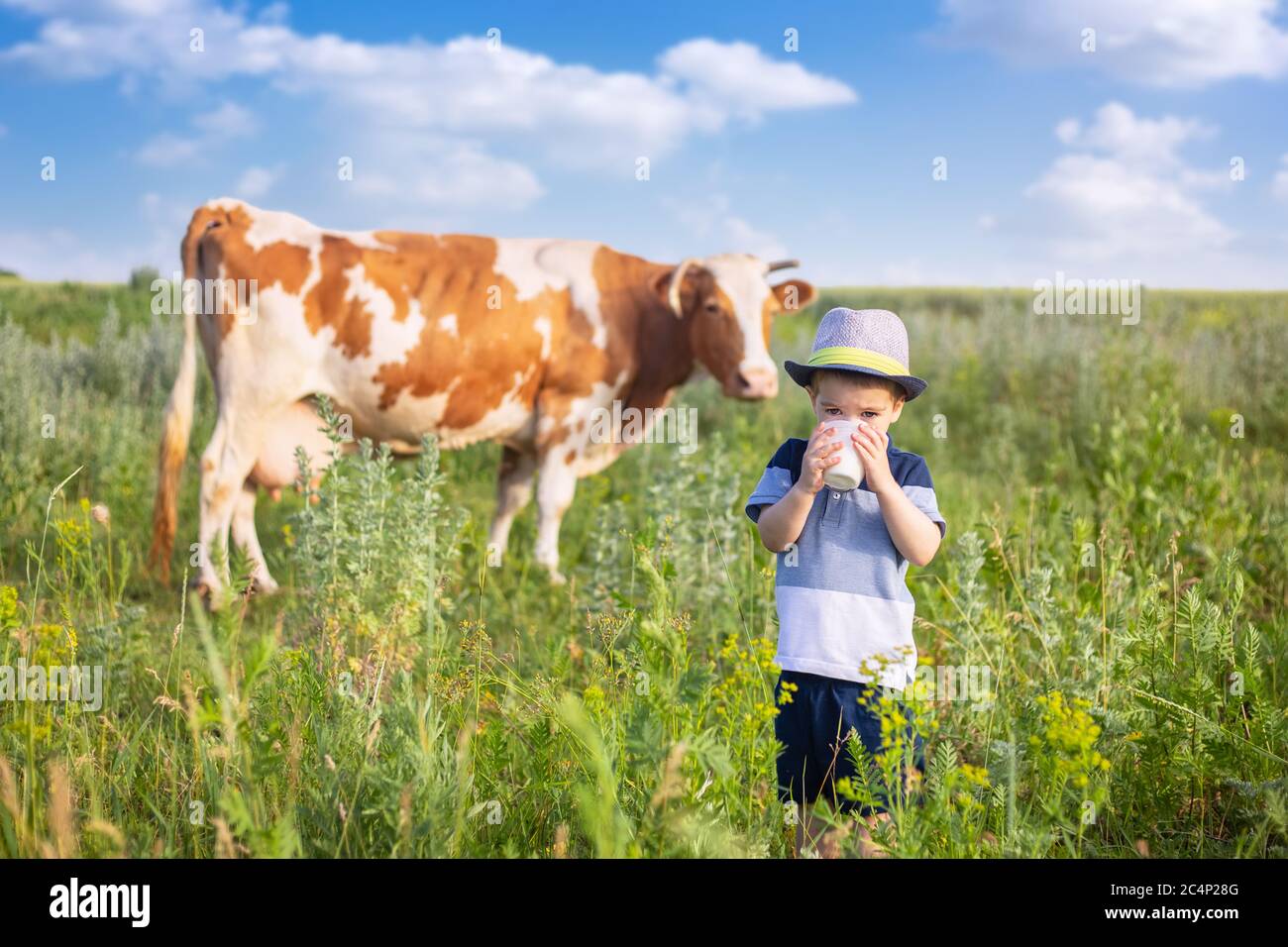 little boy drinking milk outdoors Stock Photo