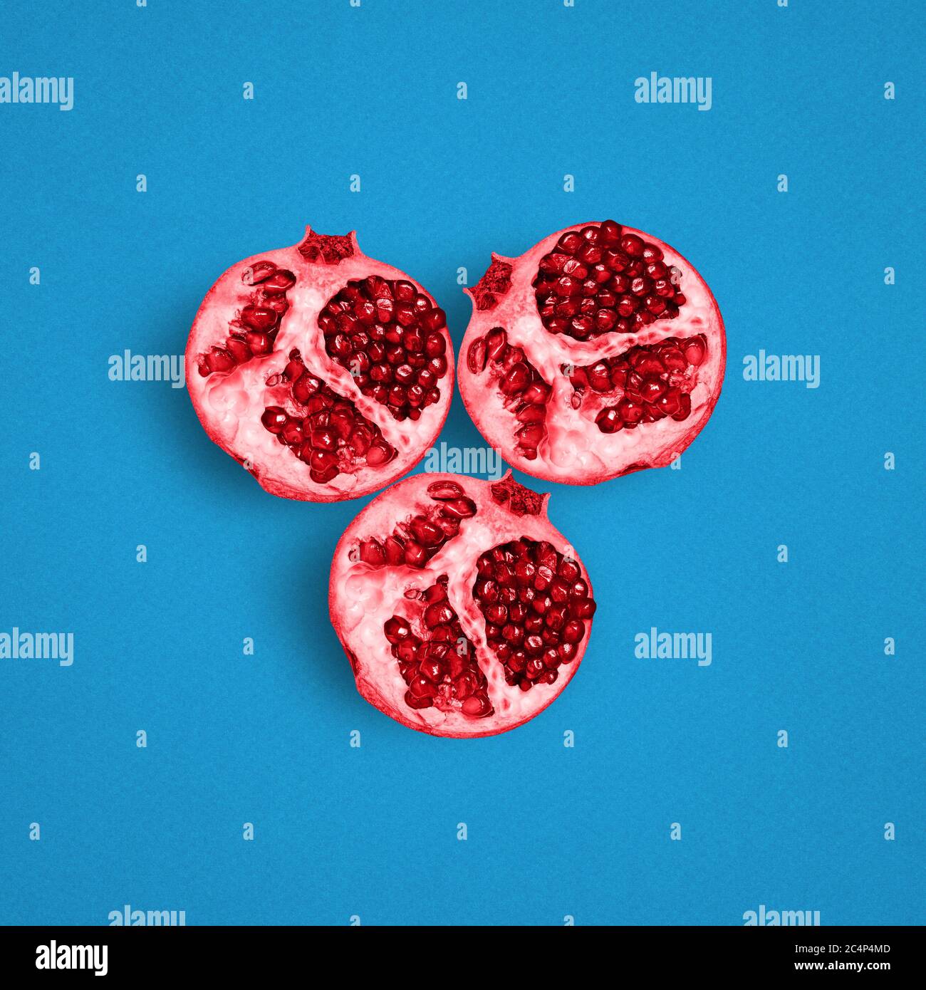 Red garnet on a blue background. A fresh and fruity background. Minimal concept. Top view, flat layout Stock Photo