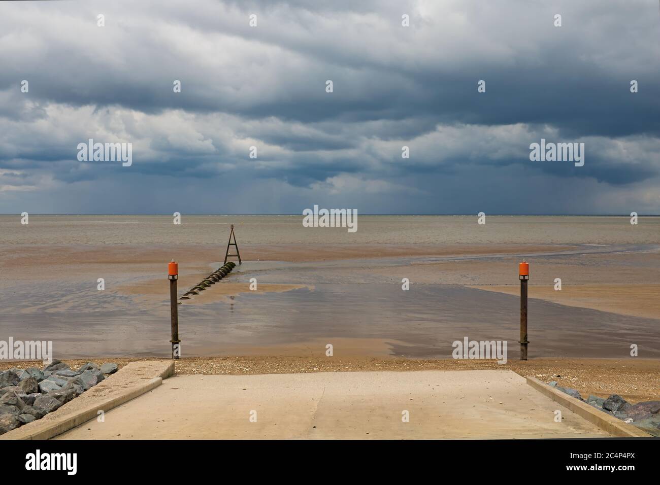 Landing ramp and groyne looking out into the Wash at low tide under a cloudy sky, Hunstanton, Norfolk, England, UK Stock Photo